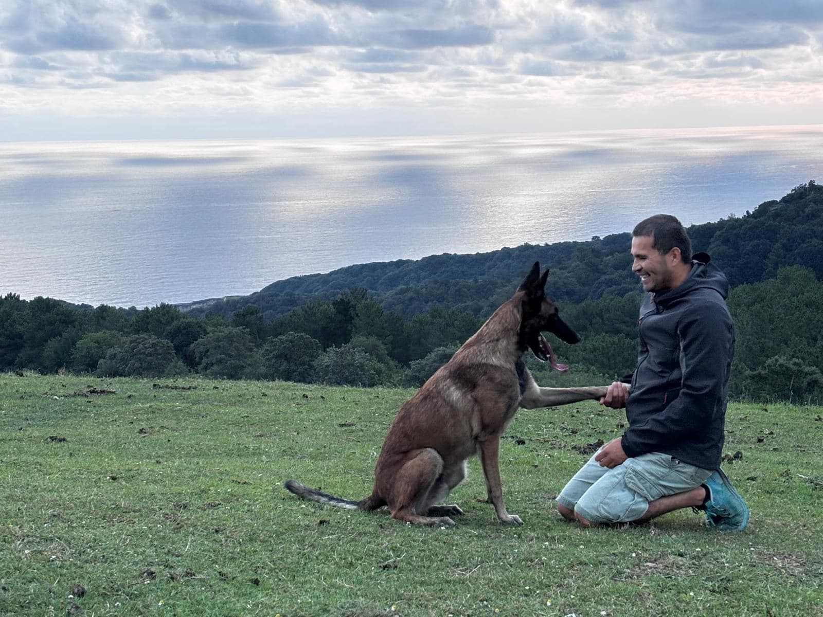 Frédéric et son chien Malinois en séance de travail face à l'océan